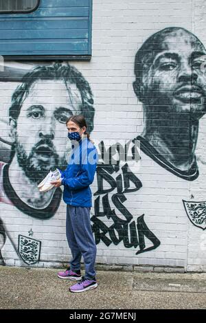 LONDON 15 Juli 2021 . Fußballfan Nick Herbert posiert mit den von ihm auf Nike von You entworfenen Harry Kane Schuhen vor dem Wandbild, das der Stadtstraßenkünstler MurWalls im Auftrag des Londoner Bürgermeisters Sadiq Khan in Essig Yard nahe der London Bridge enthüllt hat. Das Wandbild zeigt ein Bild von Manager Gareth Southgate, Kapitän Harry Kane und Raheem Sterling „You did US stolze“ und würdigt die Erfolge der englischen Fußballmannschaft beim Erreichen des Finales der Fußball-Europameisterschaft 2020. Credit amer Ghazzal/Alamy Live News Stockfoto