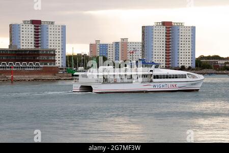 Portsmouth, England, Großbritannien. Das Passagier-Katamaran-Schiff fährt in Portsmouth Harbour vor dem Hintergrund von Wohngebäuden in Gosport, Großbritannien, ein. Stockfoto