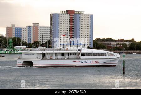 Portsmouth, England, Großbritannien. Das Passagier-Katamaran-Schiff fährt in Portsmouth Harbour vor dem Hintergrund von Wohngebäuden in Gosport, Großbritannien, ein. Stockfoto