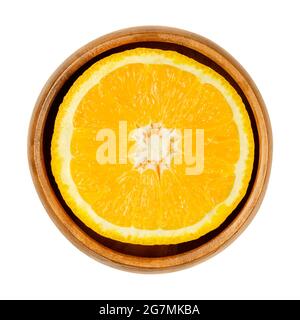 Orangefarbene Hälfte, in einer Holzschale. Querschnitt einer Valencia Orange. Reife und süße Frucht mit gelbem, saftigem Fruchtfleisch und dickem Fell. Stockfoto