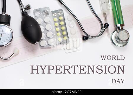 Medizinisches Foto mit Tonometer, Tabletten und Phonendoskop mit der Aufschrift World Hypertension Day Stockfoto