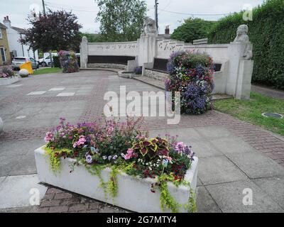 Eastchurch, Kent, Großbritannien. Juli 2021. Südost in Bloom wird in den nächsten Tagen beurteilt. Im Bild: Eastchurch Kirche und Blumen rund um das Flugdenkmal in Eastchurch, Kent heute Nachmittag. Kredit: James Bell/Alamy Live Nachrichten Stockfoto