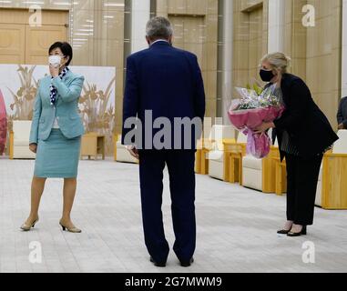 Tokio, Japan. Juli 2021. Die Gouverneurin von Tokio, Yuriko Koike (L), reagiert, als ihr an ihrem Geburtstag Blumen geschenkt werden, während Thomas Bach (C), Präsident des Internationalen Olympischen Komitees (IOC), vor ihrem Treffen in Tokio, Japan, am 15. Juli 2021 auf sie schaut. Quelle: Christopher Jue/Xinhua/Alamy Live News Stockfoto