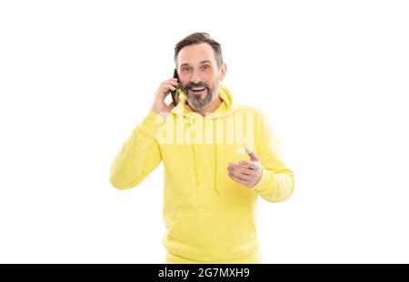 Lächelnder, hübscher, reifer Mann im Kapuzenpulli, der isoliert auf Weiß telefoniert, spricht. Stockfoto