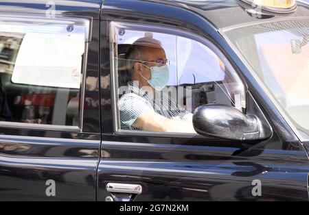 London, Großbritannien. Juli 2021. Ein Taxifahrer mit Masken. Passagiere mit Masken auf Londoner Transportmitteln. Am 14. Juli sagte der Bürgermeister von London, Sadiq Khan, dass das Tragen von Masken Ôa Bedingung von carriageÕ sein würde und für Passagiere im öffentlichen Verkehr in London obligatorisch sein würde. Die Regierung hat gesagt, dass Masken ab dem 19. Juli nicht mehr obligatorisch sein werden. Kredit: Mark Thomas/Alamy Live Nachrichten Stockfoto