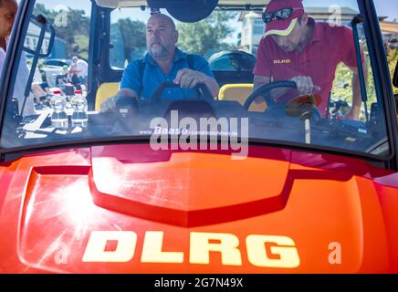 Prerow, Deutschland. Juli 2021. Harry Glawe (CDU), Mecklenburg-Vorpommerns Minister für Wirtschaft und Gesundheit, sitzt in einem speziellen Gator-Rettungsfahrzeug, das von DLRG-Rettungsschwimmern am Ostseestrand eingesetzt wird. Bei seinem Besuch erfährt der Minister von der Arbeit der DLRG-Rettungsschwimmer und den Einsatzmöglichkeiten von Allradantriebfahrzeugen bei Rettungseinsätzen. Quelle: Jens Büttner/dpa-Zentralbild/dpa/Alamy Live News Stockfoto