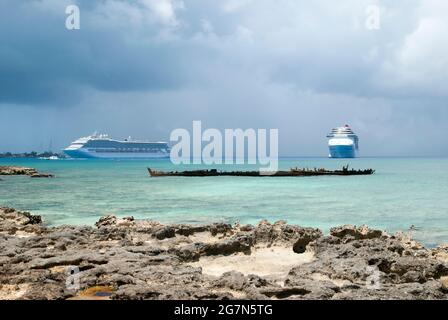 Der Blick auf zwei in der Nähe von George Town auf der Grand Cayman Insel schwebende Kreuzschiffe und die Überreste eines versunkenen Schiffes (Cayman Inseln). Stockfoto