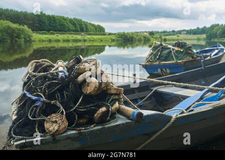 Lachsnetzboote auf dem River Tweed in Paxton in den schottischen Grenzen an einem sonnigen Sommertag mit atemberaubenden Reflexen des Himmels im Fluss. Stockfoto