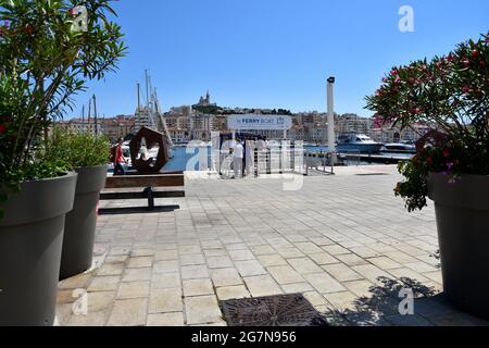 Marseille, Frankreich. Juli 2021. Menschen, die die Fähre auf dem bewachsenen Quai du Port in Marseille besteigen werden.zum zweiten Mal in Folge bietet die Stadt Marseille vom 1. Juli bis zum 31. August 2021 einen "Marseille-Sommer" an. Aus diesem Anlass wird der Quai du Port zu einer Fußgängerzone zwischen dem Ombrière und dem Fort Saint-Jean, die mit Dutzenden von Säulen voller Blumen und vegetierter Räume geschmückt ist. Kredit: SOPA Images Limited/Alamy Live Nachrichten Stockfoto