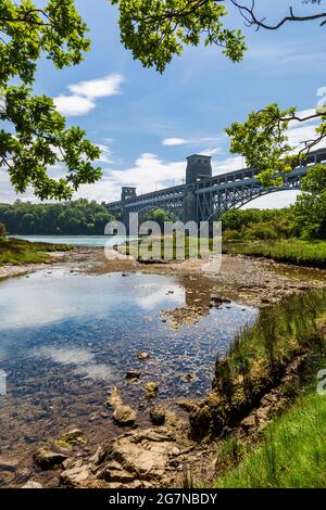 Die Britannia-Brücke von der Küste der Menai-Straße bei Ebbe, Anglesey, Nordwales Stockfoto