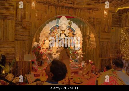 KOLKATA , INDIEN - 27. SEPTEMBER 2017 : Hindu-Priester verehrt Göttin Durga, während Dhaakis (Trommler) in seinem Rücken auftreten. Durga Puja Festival Stockfoto