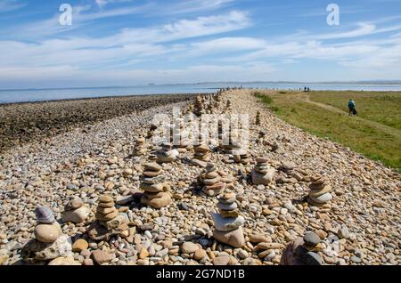 Cairns wurde von Besuchern von Lindisfarne Castle auf Holy Island vor der Küste von Northumberland im Nordosten Englands, Großbritannien, erbaut. Stockfoto