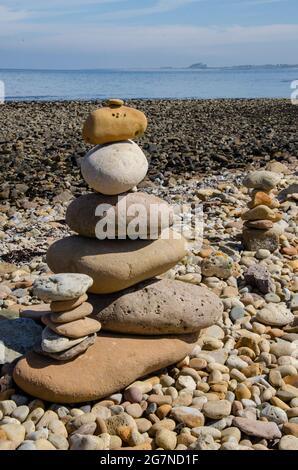 Cairns wurde von Besuchern von Lindisfarne Castle auf Holy Island vor der Küste von Northumberland im Nordosten Englands, Großbritannien, erbaut. Stockfoto