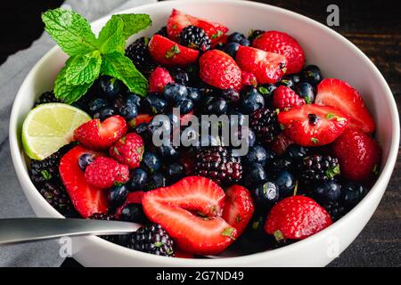 Sommer-Beerensalat mit Garnierung: Obstsalat aus Erdbeeren, Blaubeeren, Brombeeren und Himbeeren Stockfoto