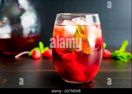 Iced Raspberry Mint Green Tea: Ein Glas eisgrünen und Kräutertee, garniert mit Himbeeren und Minzblättern Stockfoto