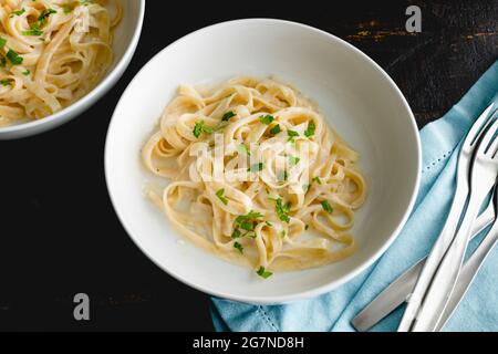 Schalen von Fettuccine Alfredo Pasta: Schalen von Nudeln in einer cremigen Parmesan-Käse-Sauce Stockfoto