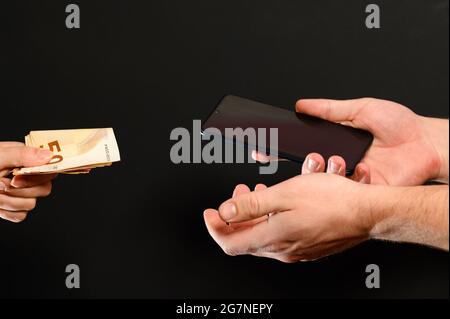 Ein Beispiel für den Einzelhandel mit Smartphones, die Zahlung von Waren in bar, das Empfangen von Geld für verkaufte Waren. Neu Stockfoto