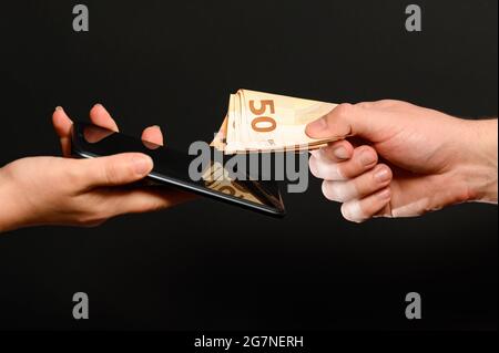 Ein Beispiel für den Einzelhandel mit Smartphones, die Zahlung von Waren in bar, das Empfangen von Geld für verkaufte Waren. Neu Stockfoto