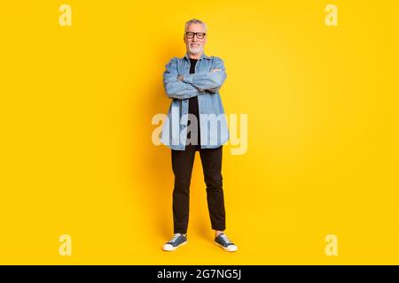 In voller Länge Foto des optimistischen Großvater gekreuzte Arme tragen Brillen Jacke Hose isoliert auf gelbem Hintergrund Stockfoto