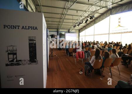 Geisa, Deutschland. Juli 2021. Zuschauer sitzen in der Fahrzeughalle des Point Alpha-Denkmals. Das Sommerkino an der Gedenkstätte geht nach einer langen Corona-Pause in die zweite Runde. Bis zum 12. August werden insgesamt vier Filme gezeigt. Quelle: Bodo Schackow/dpa-Zentralbild/dpa/Alamy Live News Stockfoto