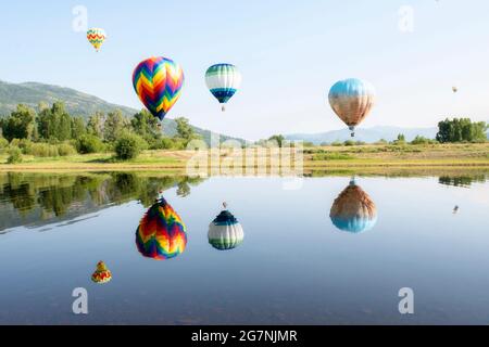Heißluftballons über einem See mit Reflexionen in Steamboat Springs, Colorado Stockfoto