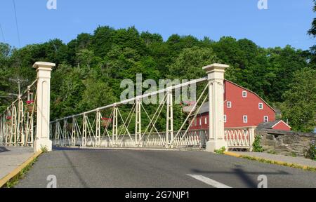 Überquerung der Brücke mit der Old Red Mill im Hintergrund in Clinton, New Jersey Stockfoto