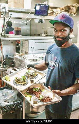 Miami Beach Florida Taquiza Restaurant Personal Koch Black man hält hält Tabletts Lebensmittel Tacos Stockfoto