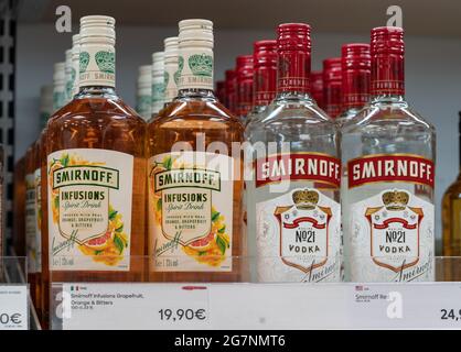 Helsinki , Finnland - 07.06.2021: Whiskey-Flaschen in den Regalen. Bekannte Marken von hochwertigem Wodka. Smirnoff Flaschen mit ihren Preisschildern in Euro. Steuerfreier Laden Stockfoto