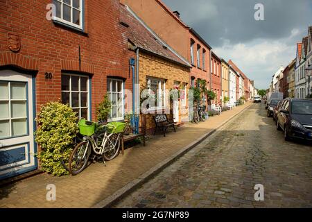 Friedrichstadt, Deutschland. Juli 2021. Die Sonne wirft Schatten auf die Häuser in einer kleinen Straße im Zentrum von Friedrichstadt. Quelle: Gregor Fischer/dpa/Alamy Live News Stockfoto