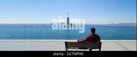 The Maiden's Tower (kiz Kulesi), Urlaub und Reise nach istanbul, man entspannt sich auf der Bank mit Blick auf den bosporus und dem Blick auf den Leandros Tower Stockfoto