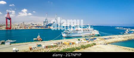 Panorama des Limassol Seehafens (Zypern) mit angedockten Kreuzfahrt- und Frachtschiffen und Frachtterminal mit Portalkranen Stockfoto