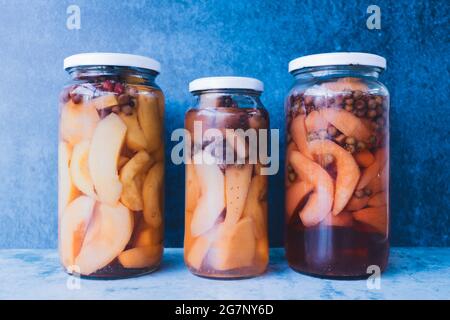 Gläser mit hausgemachten, konservierten Früchten auf blauem Hintergrund. Ernährungskonzept. Stockfoto