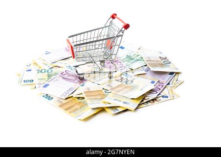 Einkaufswagen und Euro-Banknoten auf weißem Hintergrund isoliert. Stockfoto