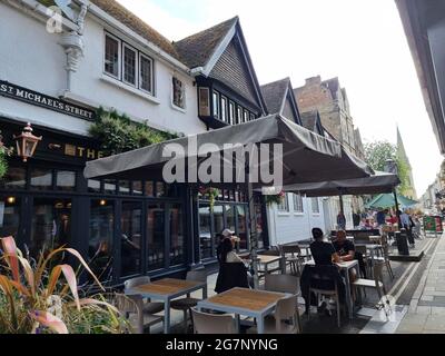 Diners in den Außenrestaurants in High Street, Oxford, England. Auf der belebten High Street in Oxford, die zur St Mary’s Church und der berühmten Radcliffe Camera führt, bilden die Restaurants mit ihren unvergleichlichen Lagen den lebendigen Mittelpunkt der Stadt. Sie bieten eine einzigartige Umgebung, in der Gäste einen Morgenkaffee, ein schnelles zwei-Gänge-Mittagessen oder ein langes festliches Abendessen im verborgenen Herzen der Stadt genießen können. Vereinigtes Königreich. Stockfoto