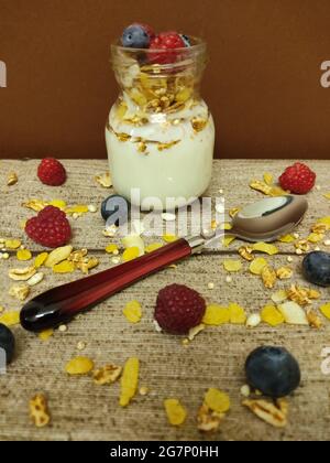 Hochgedrehter Schuss einer Schüssel mit frischem und köstlichem Müsli und einem großen Löffel auf einem Holztisch Stockfoto
