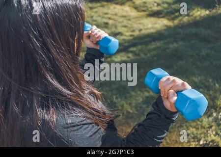 Plus size Frau mit zwei blauen Hanteln. Gesundes Leben. Fitnesskonzept Stockfoto