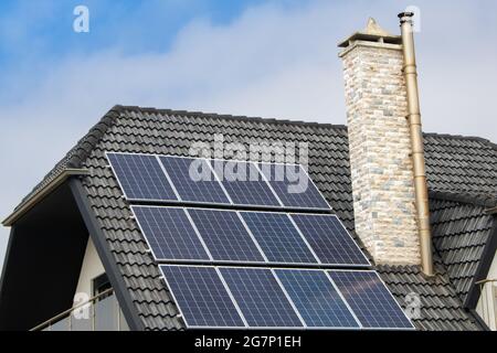 Detail des Hausdachs mit kleinen Solarmodulen oder Foto-Voltaic-Modulen Stockfoto