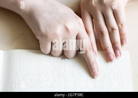 Vorderansicht einer blinden Frau, die ein Buch in Brailleschrift liest Stockfoto