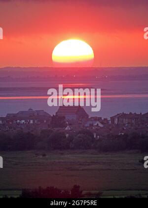 Minster on Sea, Kent, Großbritannien. Juli 2021. UK Wetter: Sonnenuntergang von Minster on Sea, Kent mit Blick auf die Stadt Sheerness (Vordergrund) und wo die Themse (obere Mitte) auf den Medway (untere Mitte) trifft, der von der Isle of Grain getrennt ist. Kredit: James Bell/Alamy Live Nachrichten Stockfoto