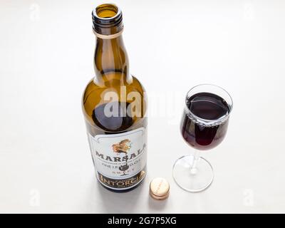 MOSKAU, RUSSLAND - 10. JUNI 2021: Weinglas und offene Flasche süßer Marsala von Cantine Intorcia. Der in der Stadt Marsala hergestellte Wein ist angereichert Stockfoto