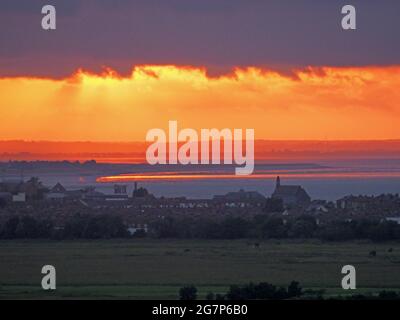 Minster on Sea, Kent, Großbritannien. Juli 2021. UK Wetter: Sonnenuntergang von Minster on Sea, Kent mit Blick auf die Stadt Sheerness (Vordergrund) und wo die Themse (obere Mitte) auf den Medway (untere Mitte) trifft, der von der Isle of Grain getrennt ist. Kredit: James Bell/Alamy Live Nachrichten Stockfoto