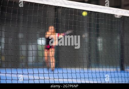 Frau spielt Padel auf dem Hallentennisplatz Stockfoto