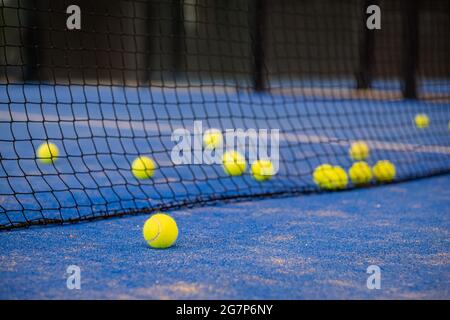 Tennisball auf dem Boden nach einem Spiel - Padel-Kugeln - Gelbe Tennisbälle auf dem Platz auf blauem Rasen Stockfoto