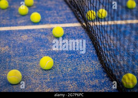 Tennisball auf dem Boden nach einem Spiel - Padel-Kugeln - Gelbe Tennisbälle auf dem Platz auf blauem Rasen Stockfoto