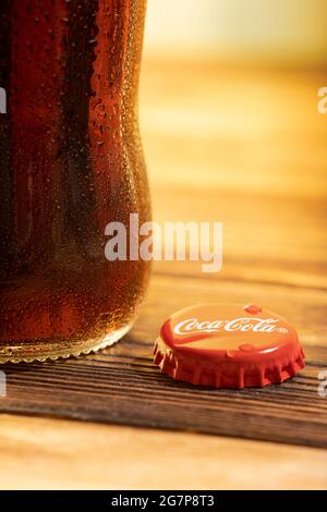 Nahaufnahme von Cola in einer Glasflasche auf einem Holztisch. Stockfoto