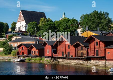 Mittelalterliche Steinkirche auf dem Hügel und alte rote Ockerlager am Fluss Porvoonjoki in der Altstadt von Porvoo, Finnland Stockfoto