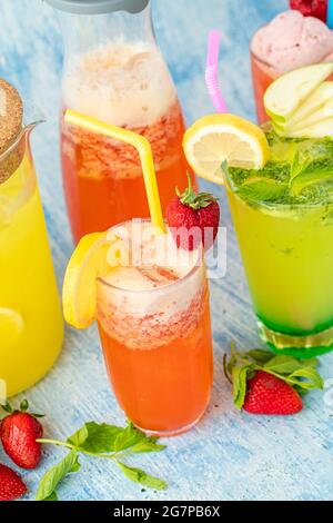Erfrischende Limonade mit Zitrone, Erdbeere und Minze auf blauem Hintergrund Stockfoto