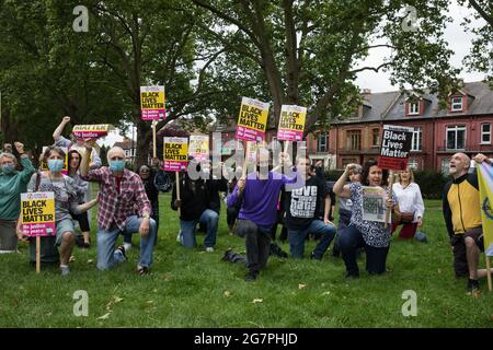 London, Großbritannien. Juli 2021. Antirassistische Aktivisten knieen in Solidarität mit den englischen Fußballern Marcus Rashford, Jadon Sancho und Bukaya Saka während einer Veranstaltung zu Ducketts Common, die von Haringey „Stand Up to Racism“ organisiert wurde. Die drei englischen Fußballer wurden nach der Endniederlage der englischen EM 2020 gegen Italien Rassenmissbrauch ausgesetzt. Kredit: Mark Kerrison/Alamy Live Nachrichten Stockfoto