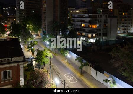 Leere Straßen bei Nacht Blick von oben in Santiago City, Chile. Wohngebäude und beleuchtete Straßen mit Bäumen. Quarantäne- und Sperrkonzepte Stockfoto