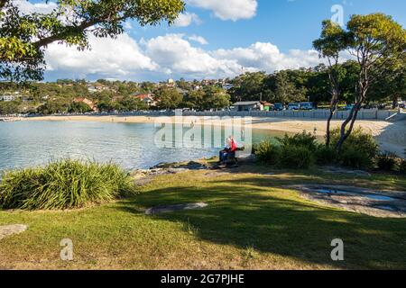 Menschen sitzen und entspannen an einem sonnigen Tag am Balmoral Beach, Sydney, Australien, während der Pandemie-Sperre Stockfoto